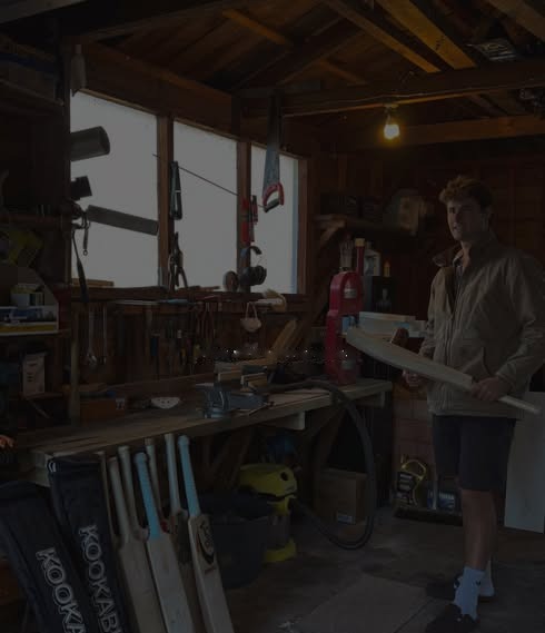 Lachie Harper holding a bat in his workshop
